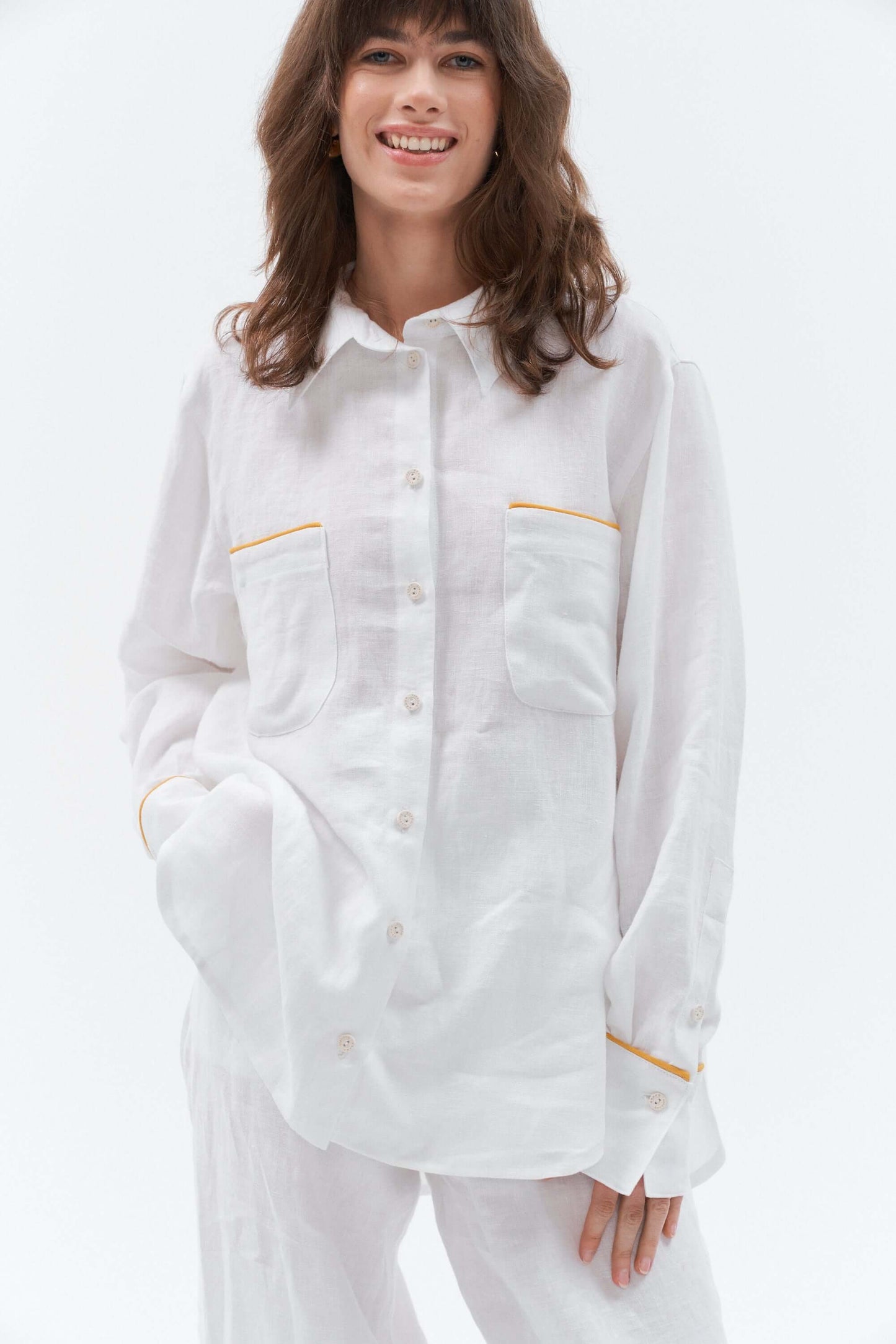 Woman wearing a white shirt with yellow accents on a white background
