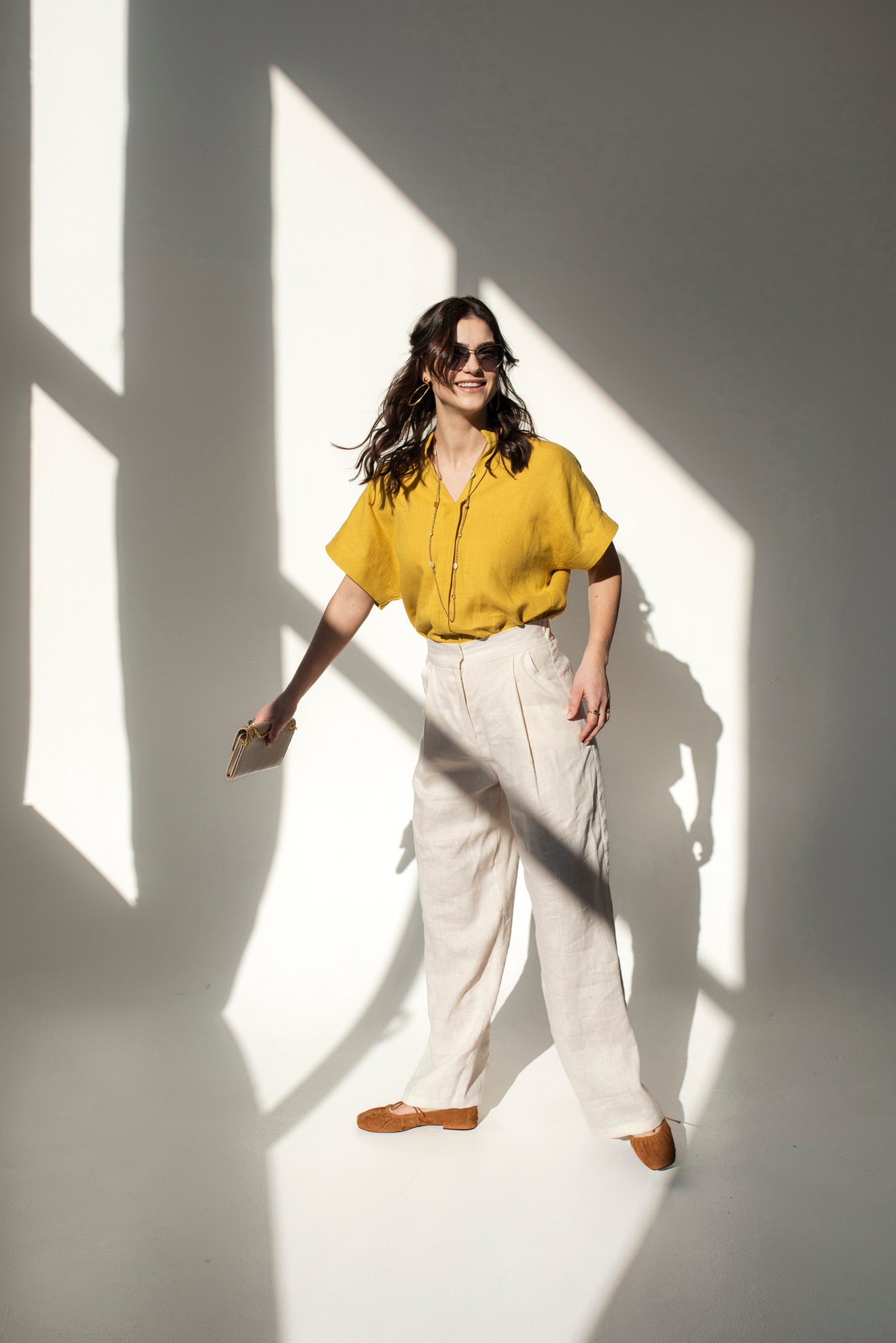 Front view of a woman wearing a mustard yellow Japanese style linen top with short sleeves and a V-neck collar, paired with a beige color linen pants Independence II.