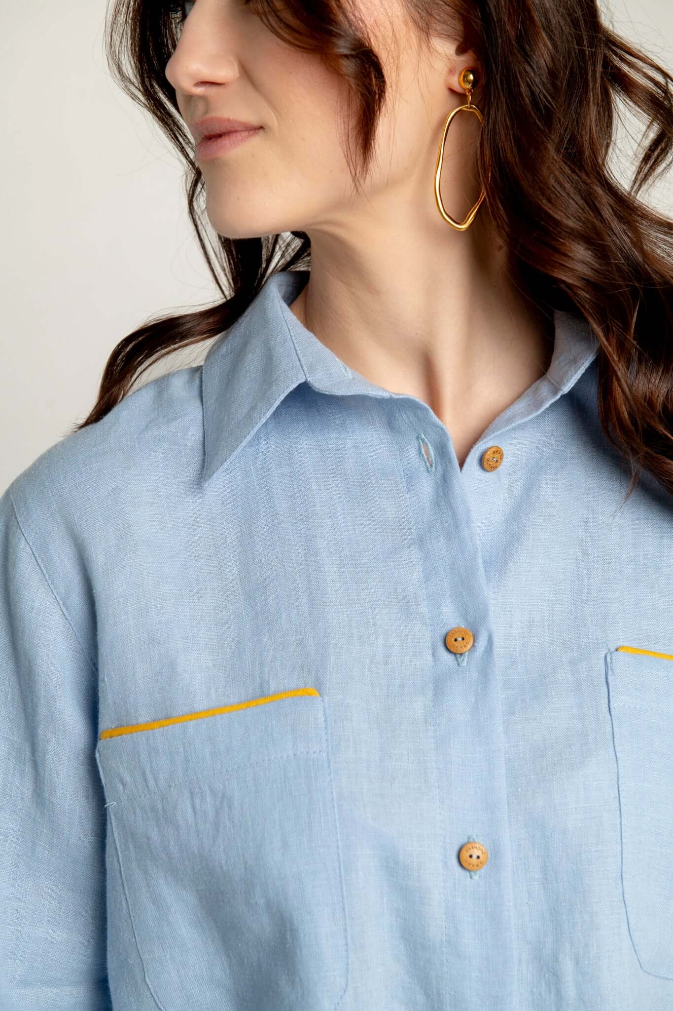 Light blue shirt with yellow accents worn by a person, focusing on the collar and chest area.