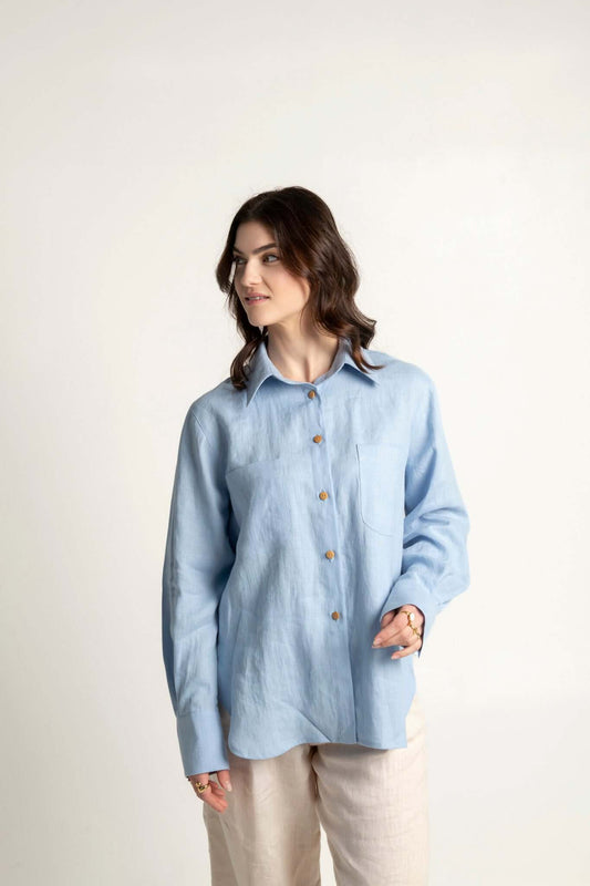 Woman wearing a light blue long sleeve oversized linen shirt Brillante, styled for casual elegance.