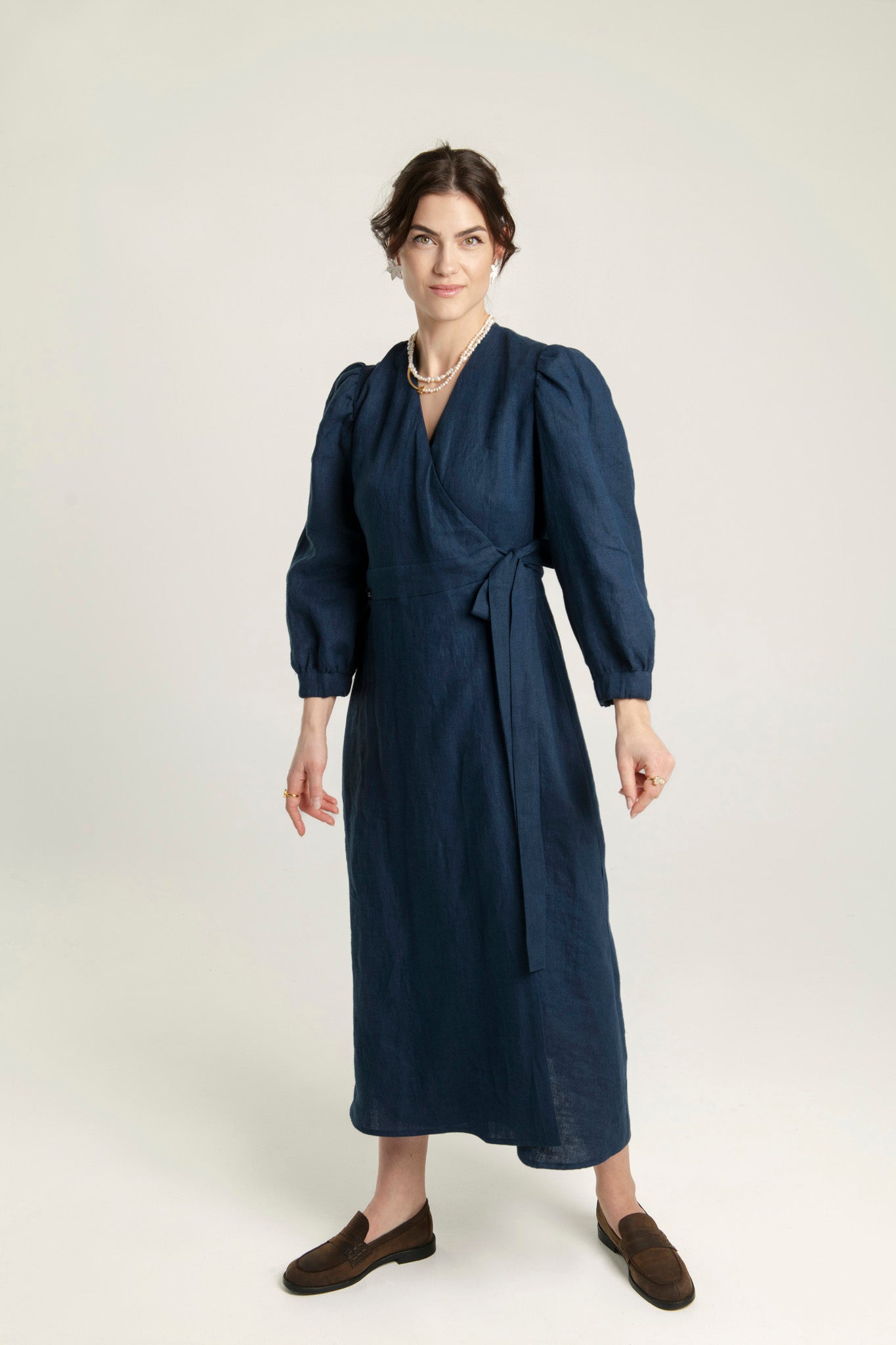 Linen midi dress with crossover fit-and-flare design and side pockets.